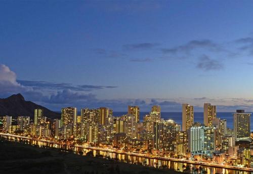 eine große Stadt in der Nacht mit einer langen Reihe von Gebäuden in der Unterkunft Modern Studio - Heart of Waikiki with Parking! in Honolulu