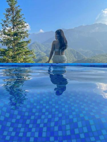 a woman standing in the water next to a swimming pool at Catcat Garden House in Sa Pa