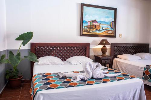 Habitación de hotel con 2 camas y toallas. en Hotel Hacienda del Mar, en Carrillo
