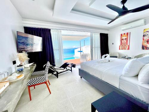 a bedroom with a large bed and a desk with a chair at Epic Suites Bohol ADULTS ONLY in Dauis