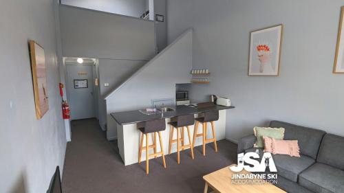 a small living room with a table and a couch at Razorback 14 in Jindabyne