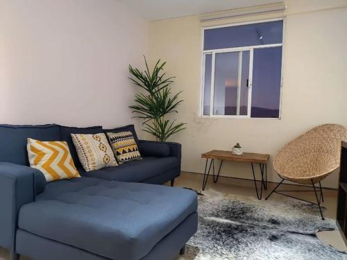 a living room with a blue couch and a window at Moderno y Tradicional, elegante departamento en Oaxaca in Oaxaca City