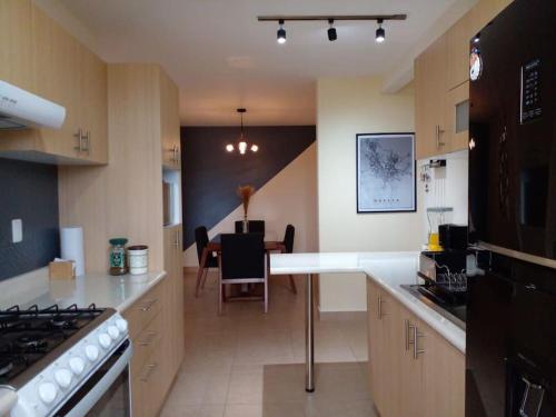 a kitchen with a counter top and a dining room at Moderno y Tradicional, elegante departamento en Oaxaca in Oaxaca City