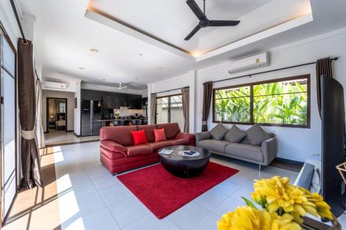a living room with a red couch and a red rug at 3 Bedroom Pool Villa in Great Location! BUB in Hua Hin