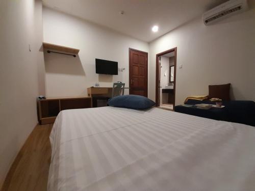 a bedroom with a large white bed and a television at Happy Home in Nha Trang