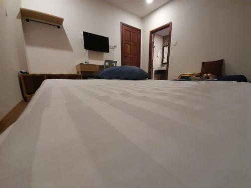 a large white bed in a room with a television at Happy Home in Nha Trang