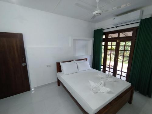 a bedroom with a bed with a flower on it at Water Front Home Stay and Resort in Anuradhapura