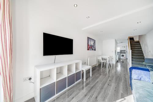 a living room with a flat screen tv on a wall at Entire House - Three Bed House in Peckham in London