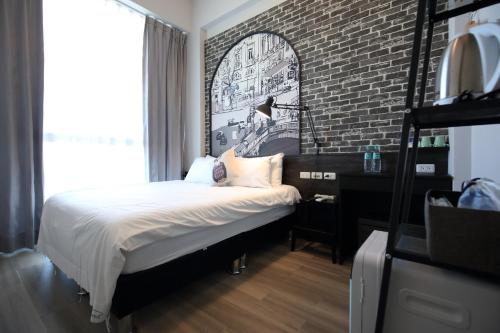 a bedroom with a bed and a brick wall at 海享電梯民宿-近夜市-近海邊 in Hualien City