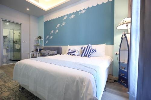 1 dormitorio con 1 cama grande y pared azul en 海享電梯民宿-近夜市-近海邊 en Hualien