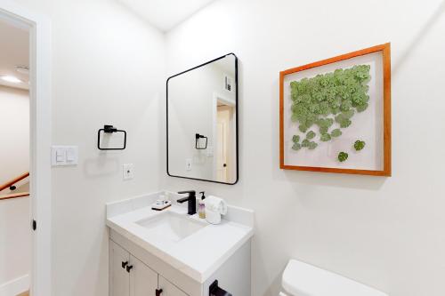 uma casa de banho branca com um lavatório e um espelho em Heavenly Oasis em Scottsdale