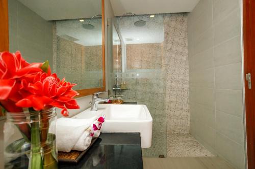 a bathroom with a sink and a vase with red flowers at Andakiri Private Pool Villa Sea View in Ao Nang Beach