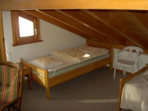 - une petite chambre avec un lit et une chaise dans l'établissement Ferienwohnung Munt plan immez 140B, à Ftan