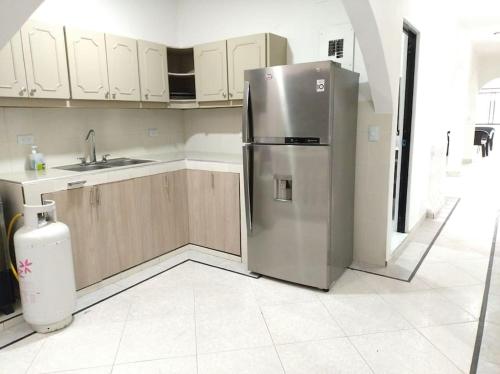 una cocina con nevera de acero inoxidable y armarios en Apartamento céntrico, cómodo y completamente privado en Cali, en Cali