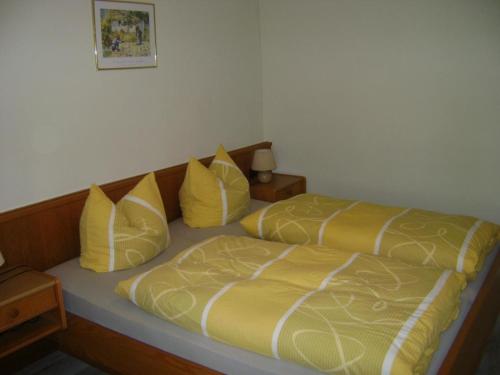 1 dormitorio con 2 camas con almohadas amarillas en Renoviertes Ferienhaus in Lauba mit Grill, Terrasse und Garten en Lawalde