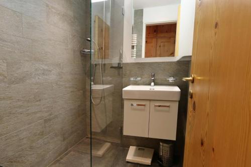 La salle de bains est pourvue d'un lavabo et d'une douche. dans l'établissement Apartment Piz Cotschen, à Pontresina