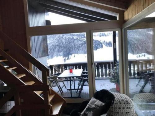 a room with a large window with a view of a table at Chalet Toggi in Wildhaus