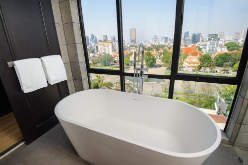 a bath tub in a bathroom with a large window at GLOW PARK HOTEL Grand Royal Palace in Phnom Penh