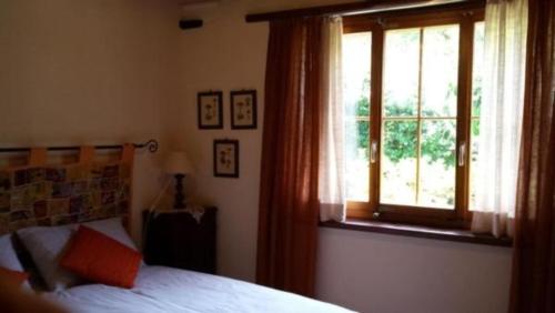 Schlafzimmer mit einem Bett und einem Fenster in der Unterkunft Casa San Cristoforo - "Atelier" in Maggia