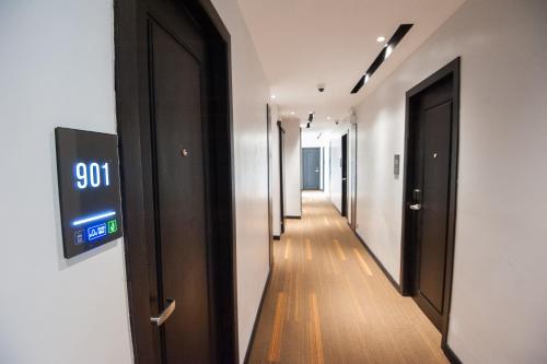 a hallway with doors and a clock on the wall at GLOW PARK HOTEL Grand Royal Palace in Phnom Penh