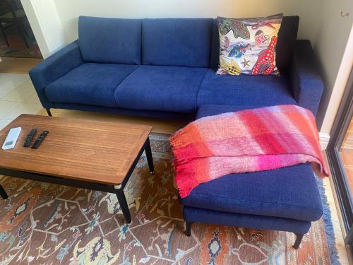 a living room with a blue couch and a coffee table at West End Apartments in Fremantle