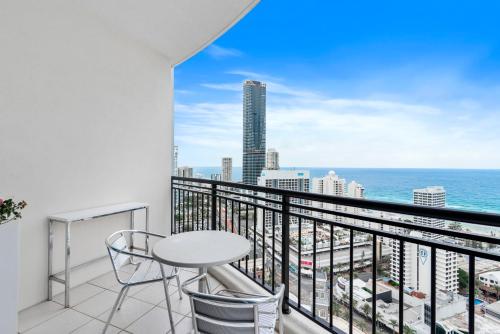 a balcony with a table and chairs and a view of the ocean at 2 Bedroom Beach View Apartment in Surfers Paradise! Free Parking & Wifi in Gold Coast