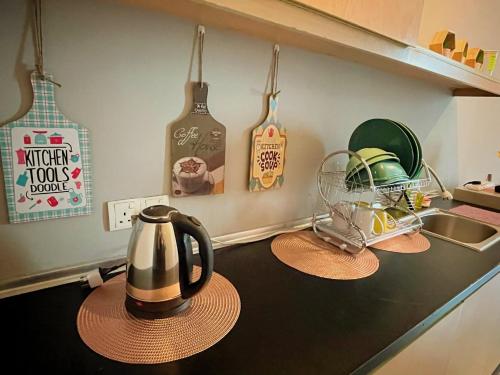 a kitchen counter with two straw hats and a tea kettle at Homey Studio Empire Damansara FreeWiFi Netflix in Petaling Jaya