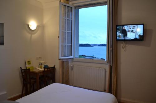 サン・マロにあるHôtel La Porte Saint Pierre-Logis Hôtel Intra Murosのベッドルーム1室(水辺の景色を望む窓付)
