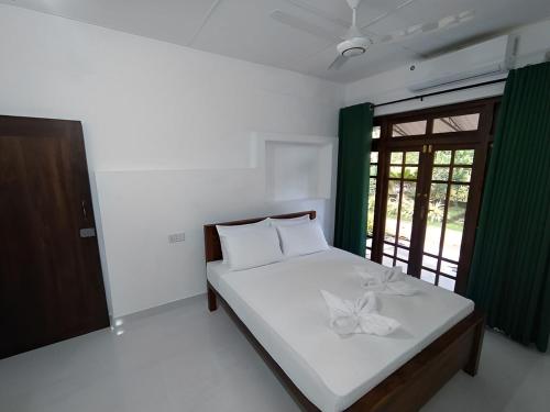 a bedroom with a bed with a flower on it at Water Front Home Stay and Resort in Anuradhapura