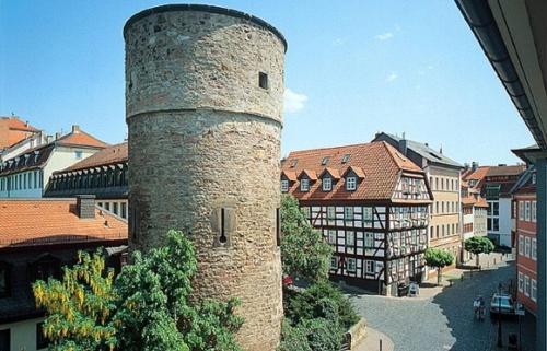 a tall brick tower in a town with buildings at Rhönblick Landhotel - Restaurant - Countrypub in Petersberg