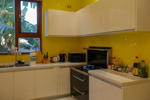 a kitchen with white cabinets and a stove top oven at Hanamitsu Hotel & Spa in Garapan
