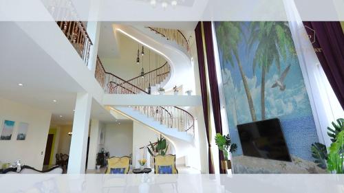 a living room with stairs in a house with a tv at Hanamitsu Hotel & Spa in Garapan