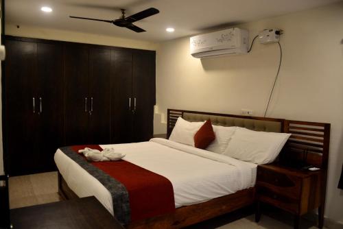 a bedroom with a bed with a ceiling fan at The Butterfly Luxury Serviced Apartments in Visakhapatnam