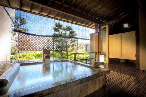 a large room with a large window and a hot tub at Grandia Housen in Awara