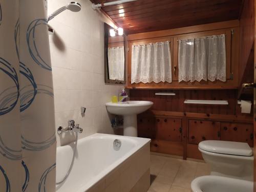 bagno con vasca, lavandino e servizi igienici di Mansarda Accogliente Falcade Dolomiti a Falcade
