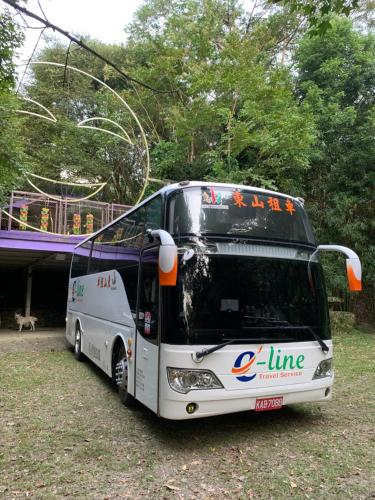 un bus garé dans un champ à côté d'un pont dans l'établissement Yun Meng Shanlin B&B, à Taian