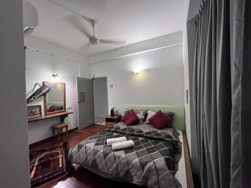 1 dormitorio con 1 cama grande con almohadas rojas en RUMAH SINGGAH APARTMENT, en Kuah