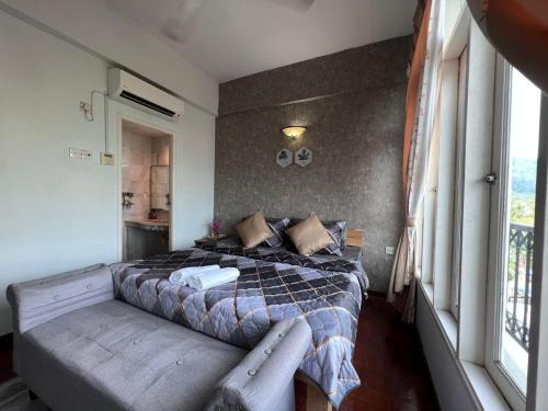 a bedroom with a bed with a bench next to a window at RUMAH SINGGAH APARTMENT in Kuah