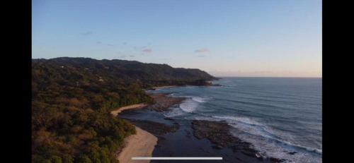 an aerial view of a beach and the ocean at Shark Town Mal Pais in Santa Teresa Beach
