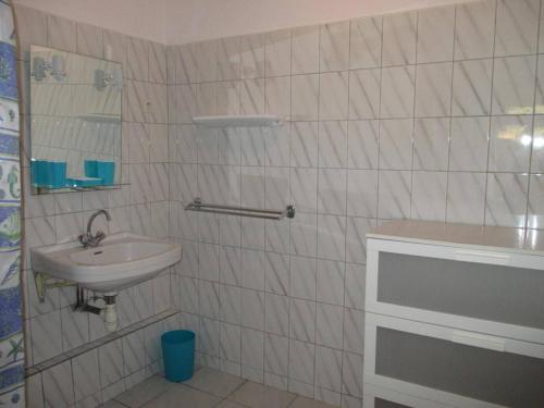 La salle de bains est pourvue de carrelage blanc, d'un lavabo et d'un miroir. dans l'établissement Appartement 2P 5 Pers avec Parking à Banyuls-sur-Mer - FR-1-225C-333, à Banyuls-sur-Mer