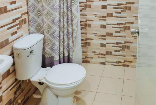 La salle de bains est pourvue de toilettes, d'un lavabo et d'une douche. dans l'établissement Irah's Guest House, à Banhigan