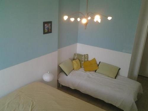 - une chambre avec 2 lits et des oreillers jaunes dans l'établissement Beau T2 face mer, balcon, accès direct plage, St Gilles Croix de Vie - FR-1-324-125, à Saint-Gilles-Croix-de-Vie