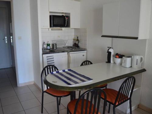 - une cuisine avec une table, des chaises et un comptoir dans l'établissement Studio cabine 4 pers. avec terrasse et WIFI à Banyuls-sur-Mer - FR-1-225C-535, à Banyuls-sur-Mer