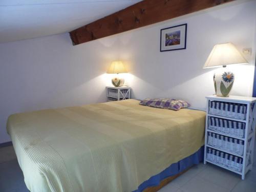 une chambre avec un lit et deux tables de nuit dans l'établissement Maison avec Terrasse et Piscine, Climatisation, Parking Privé, 34340 Marseillan - FR-1-326-660, à Marseillan