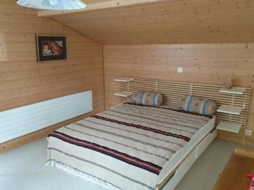 a bedroom with a large bed in a wooden room at Ferienwohnung Mänimatte in Frutigen
