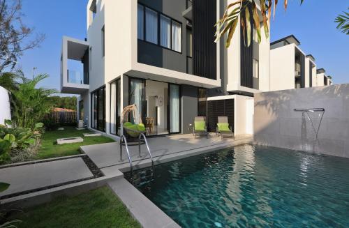 a villa with a swimming pool in front of a house at Laguna Park 2 in Phuket