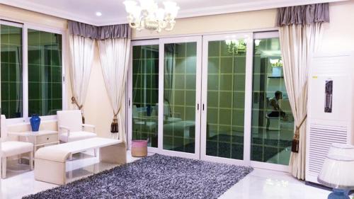 a living room with white furniture and glass doors at Hanamitsu Hotel & Spa in Garapan