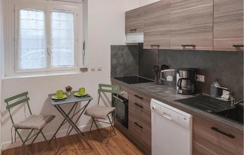 une cuisine avec un comptoir, une table et des chaises dans l'établissement Amazing Apartment In Mareil-marly With Kitchen, à Mareil-Marly