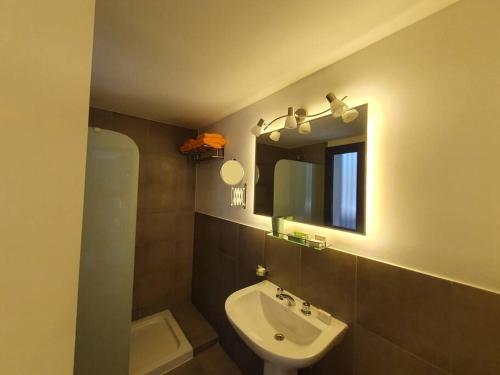 a bathroom with a sink and a mirror at Acogedor Departamento Vista a Cordillera in Godoy Cruz