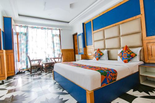 een slaapkamer met een groot bed en een tafel bij FabHotel Rosewood Inn I in Dharamshala